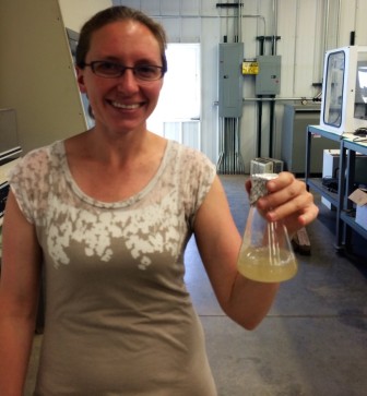 Karen Wawrousek holding up a flask of chemoautotrophic (CAT) bacteria.