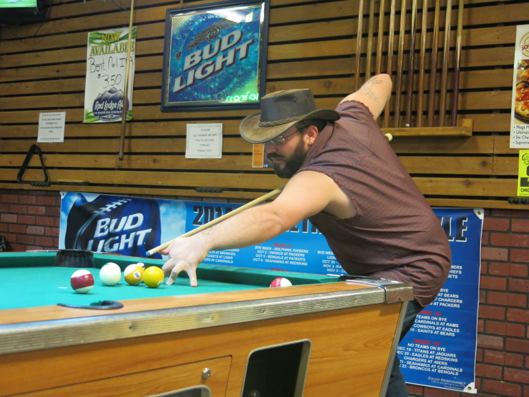 Energy worker Brandon Allee shoots pool at Jake's Tavern in Gillette, WY.