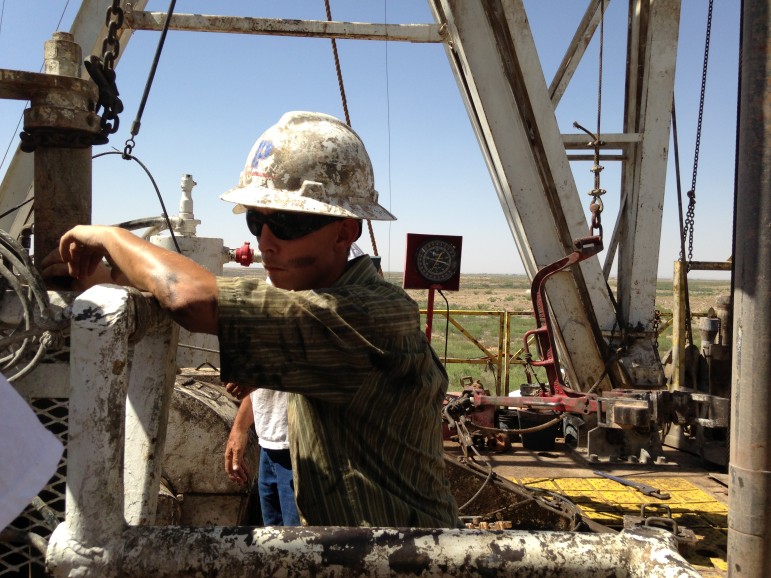 A young worker takes a short break atop a drilling rig outside Lovington, New Mexico.