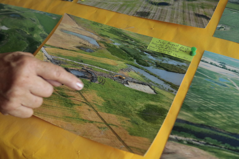 Christine Peterson points at an aerial photo of a wastewater spill near her land in Bottineau County, North Dakota.