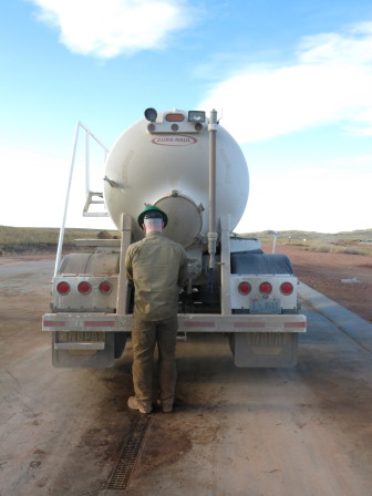 An employee of Black Bison Water Services prepares a truck to unload wastewater.