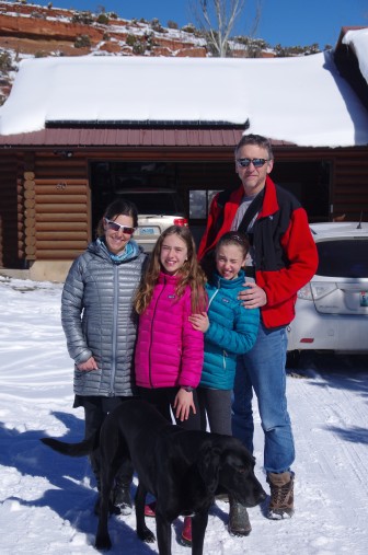 The Copeland Family in front of their snow-covered solar panels. L-R: Holly, Abby, Mia, Scott