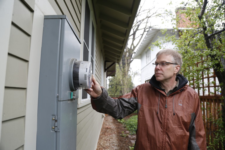 John Phelan with Fort Collins Utilities inspects the smart meter at his home.