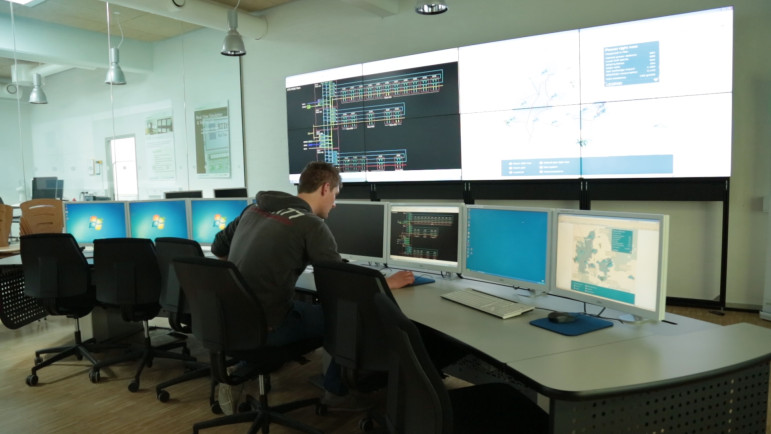 Graduate student Alexander Hermann pulls up power flow diagrams for the Danish island of Bornholm in the grid control room at PowerLabDK