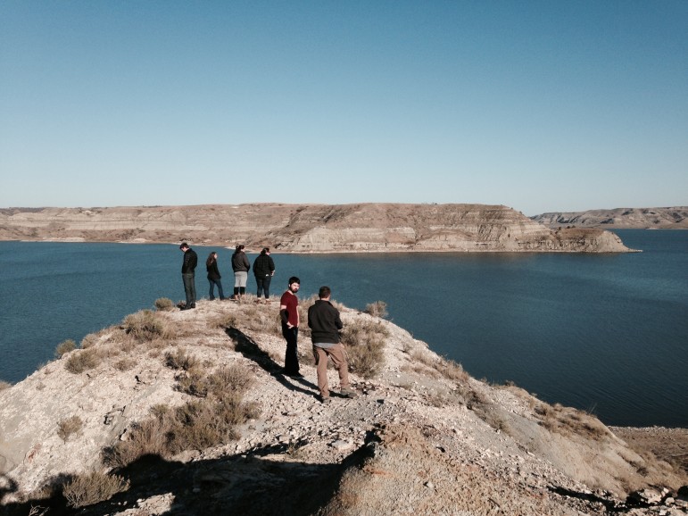 The University of Colorado Team stands with Prairie Rose Seminole on a bluff overlooking Lake Sakakawea, observing native plants and the changing landscape.