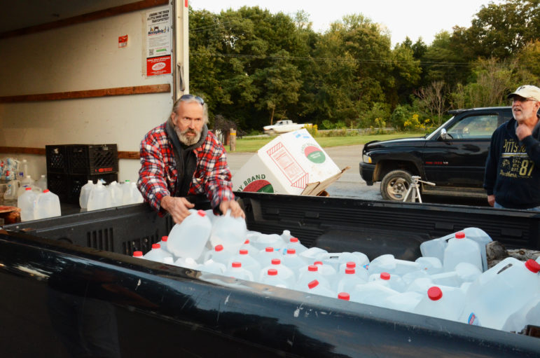 Fred McIntyre loads donated drinking water into a resident’s truck in Connoquenessing Township.